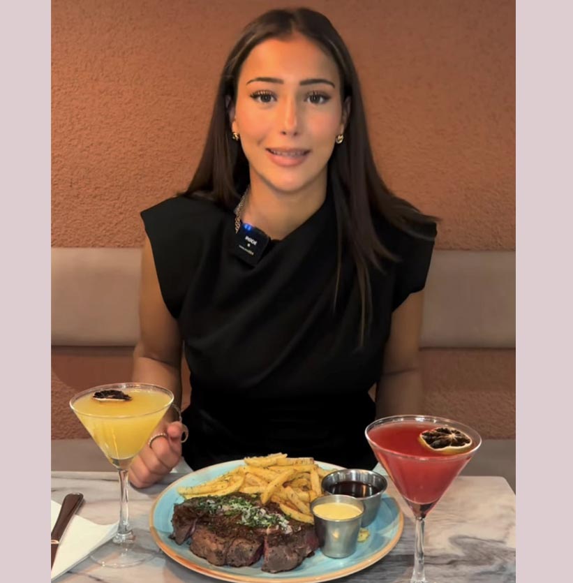Kvinna med entrecôte, pommes och två cocktails