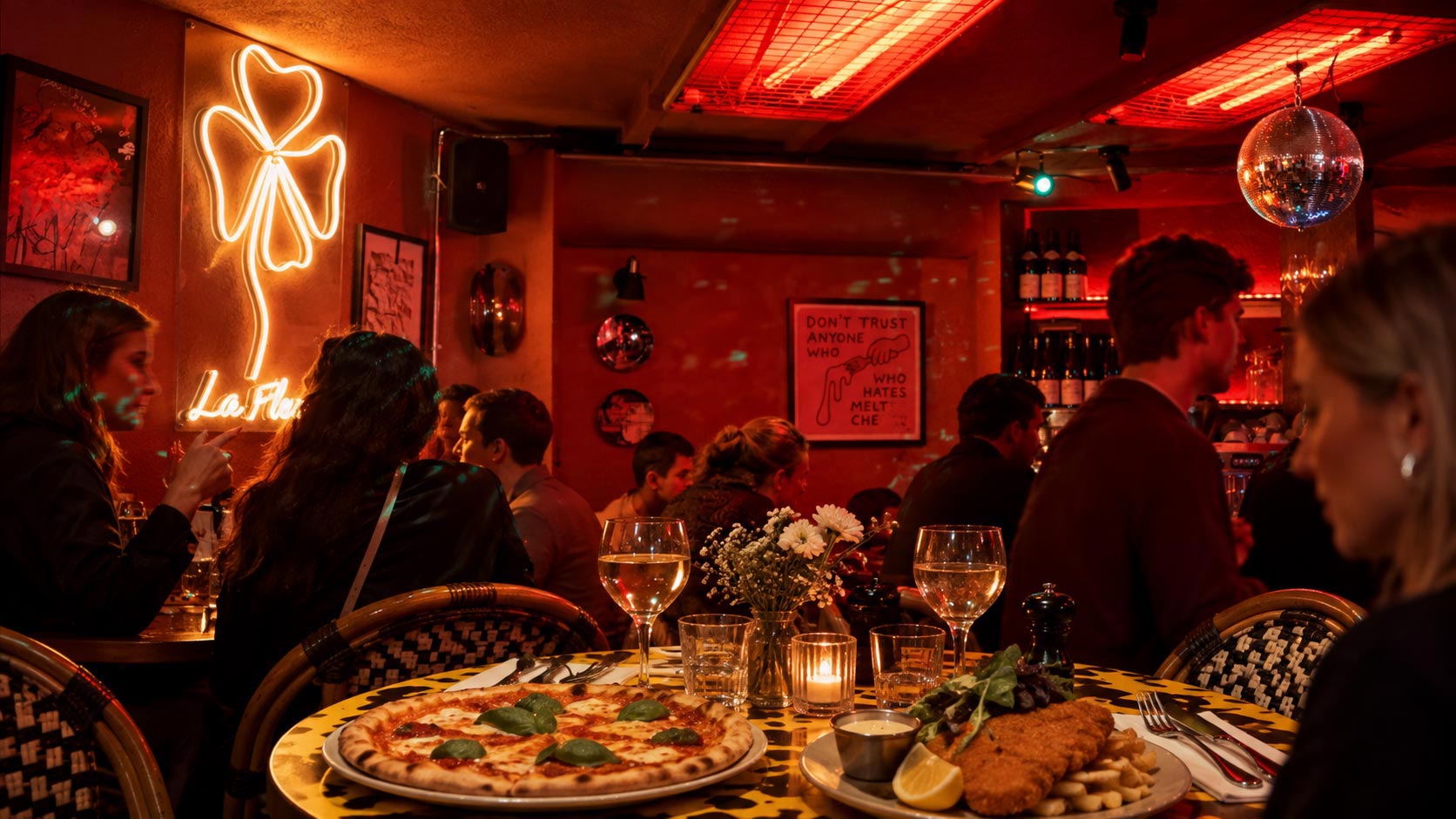 Gäster njuter av middag med pizza, viner och stämningsfull belysning